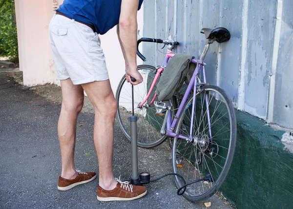 Die Hände des Mannes pumpen Rad — Stockfoto