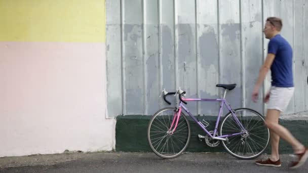 Jovem vem e vai andar de bicicleta — Vídeo de Stock