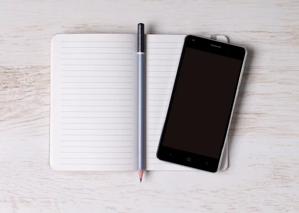 Notebook com um smartphone — Fotografia de Stock