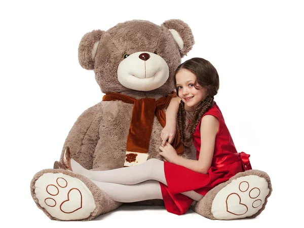 Pequena morena menina sentado no um Grande urso brinquedo — Fotografia de Stock