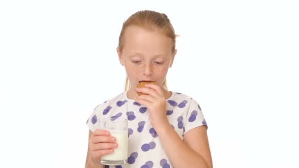 Little girl eating a cookie and drinking milk — Stock Video