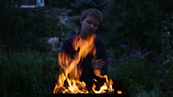 Mulher aquecendo as mãos perto do fogo — Vídeo de Stock