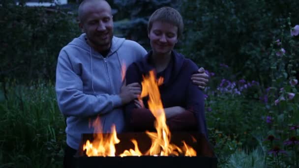 Casal jovem está parado perto do fogo — Vídeo de Stock