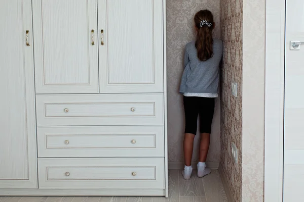 Маленька дівчинка стоїть у кутку — стокове фото