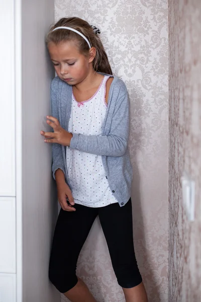 Маленька сумна дівчинка стоїть у кутку — стокове фото
