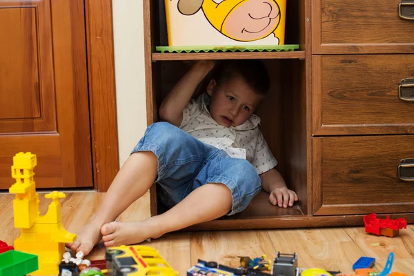 Маленький мальчик прячется в шкафу — стоковое фото