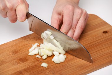 Cutting the vegetables with a kitchen knife on the board clipart