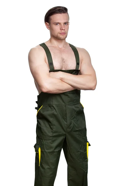 A man with a naked torso in dark green overalls — Stock Photo, Image