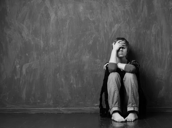 Aile içi şiddet - umutsuz kadın duvara oturuyor
