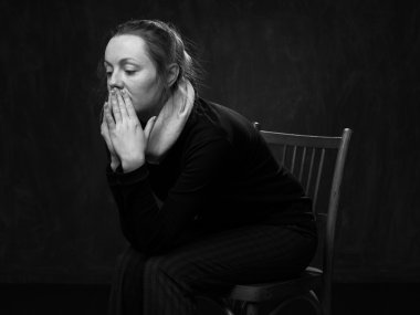 Genç üzücü şaşırmış kadın sandalyede oturuyor