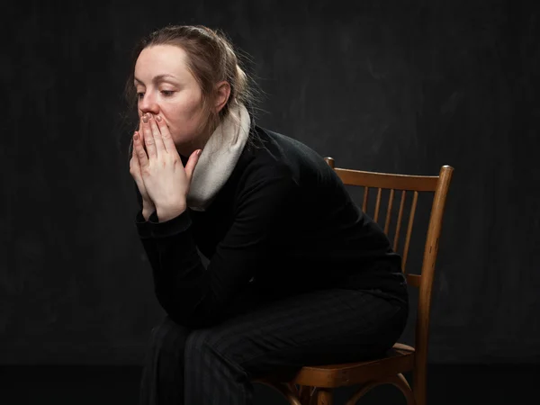 Young sad disoriented woman sitting on the chair — Stock Photo, Image