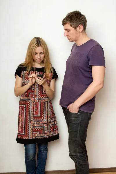 Jeune couple contre le mur, femme regarde l'écran de — Photo