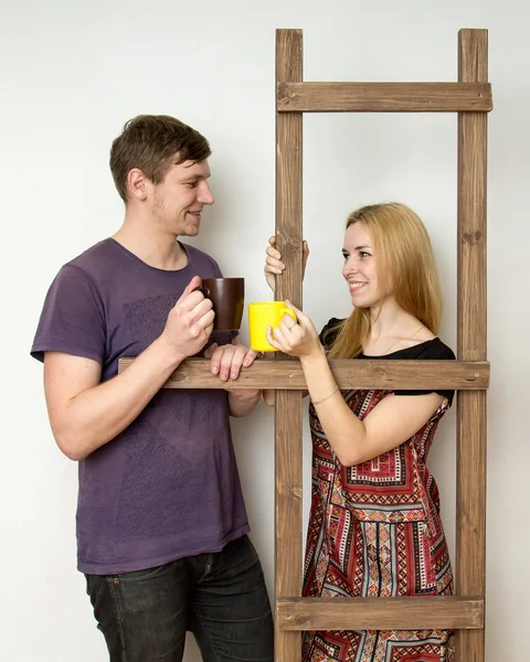 Una coppia con coppe sta riposando durante la riparazione vicino a una co di legno — Foto Stock