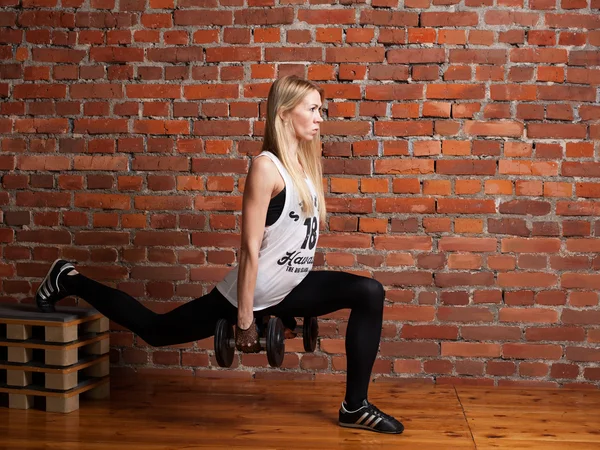 Lunges dumbbells ile belgili tanımlık sille gerçekleştirme genç fitness modeli