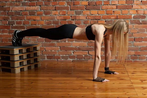 Привлекательная блондинка фитнес-модель, которая отжимается с коробкой — стоковое фото