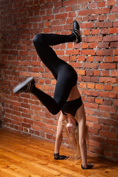 Fitness model in zwarte top en beenkappen uitvoeren handstand — Stockfoto