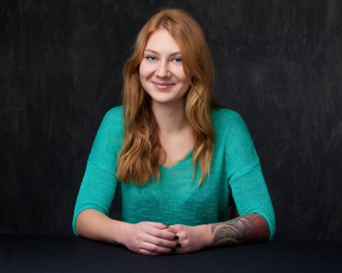 Turkuaz bluz gülümseyen genç bir zencefil Bayan portresi