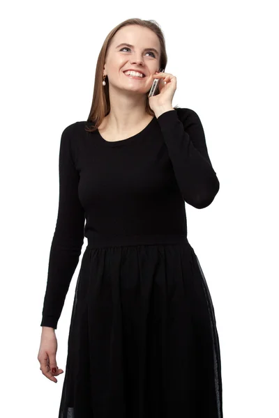 Mujer de cabello castaño con un vestido negro está hablando por teléfono . — Foto de Stock
