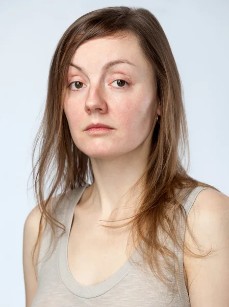 Portréja egy szomorú nő, egy bézs színű póló — Stock Fotó