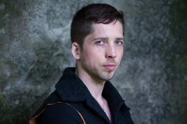 Genç bir adamiçin de üzgün gözlerle çerçeve içine bakarak bir mavi yelek,