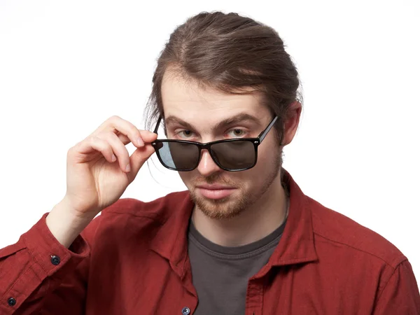 Молодий чоловік дивиться нерівності над сонцезахисними окулярами — стокове фото