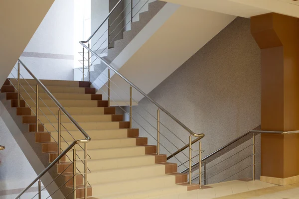 Brown staircase with metal railing, gray wall — Stockfoto