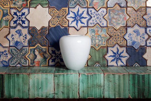White vase on the fireplace shelf , bright tile,  decorated wall Stock Picture