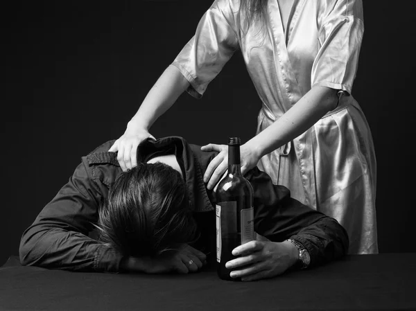 Alcoholism. Drunk man is sleeping on the table with the bottle i — Stock Photo, Image