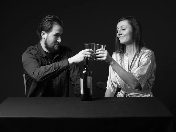 Mann und Frau trinken, Flasche auf dem Tisch, halten Gläser, — Stockfoto