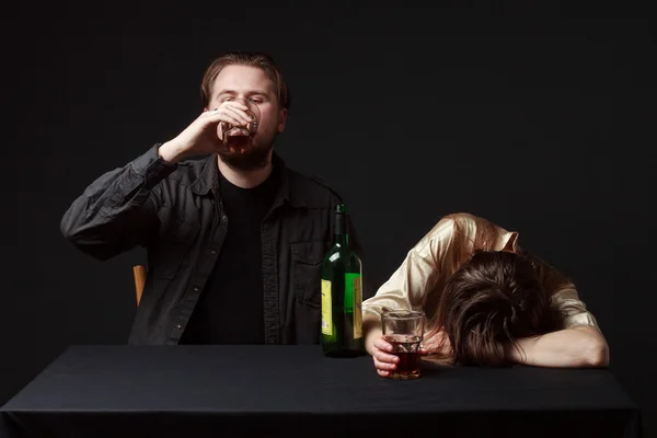 Betrunkene Frau schläft auf dem Tisch, ihr Mann ist Steel Kee — Stockfoto