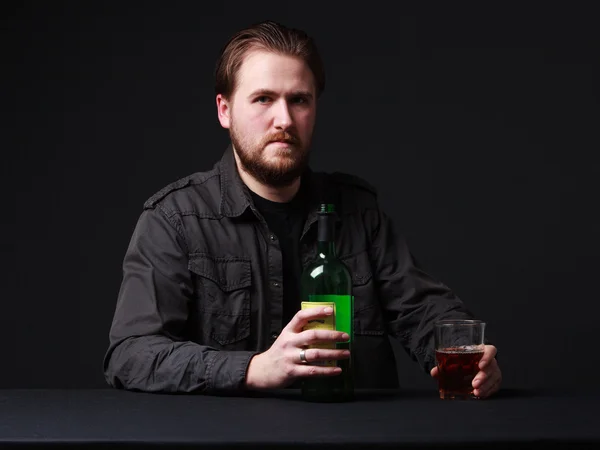 Junger Mann trinkt Alkohol aus einem Weinglas, Flasche auf dem T — Stockfoto