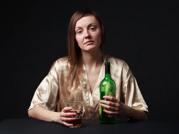 Alcoolisme. Jeune femme garde une bouteille et un verre à vin — Photo