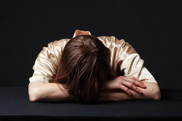 Desespero. Mulher está deitada na mesa, cabeça nas mãos — Fotografia de Stock