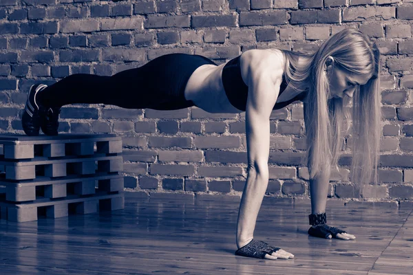 Atractivo modelo de fitness rubio realizando flexiones con una caja — Foto de Stock