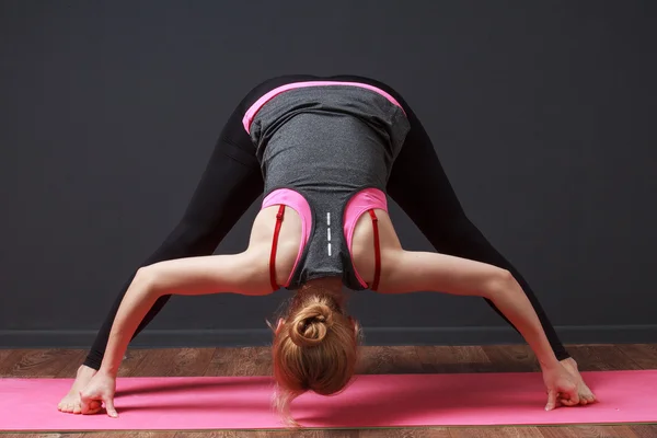 Du yoga. Courbure profonde avec les jambes chevauchées. Femme faisant de l'exercice . — Photo