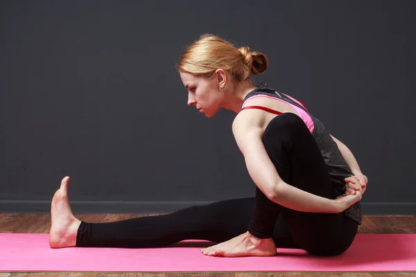Mujer rubia joven haciendo ejercicio de yoga — Foto de Stock