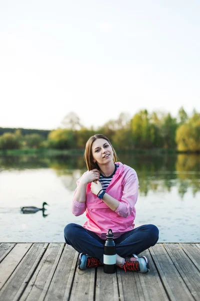 Hipster meisje zit op de pier — Stockfoto