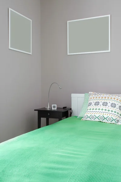 Зеленая кровать с тумбочкой — стоковое фото