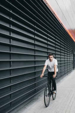 Adam siyah fixedgear bisiklet ile gidiyor