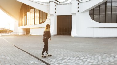 Kız şehirde bir longboard rides