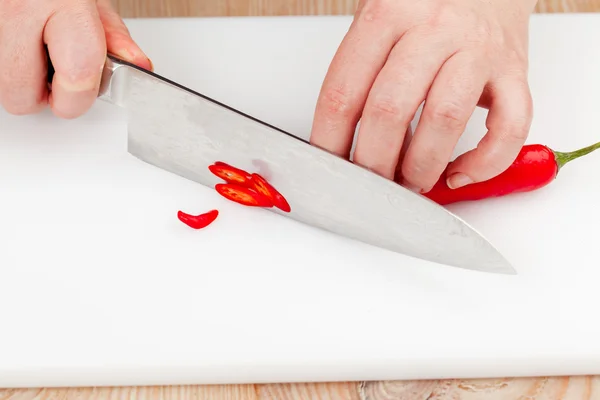 Cutting chili peppers — Stock Photo, Image