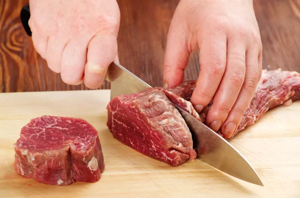 Cutting raw beef — Stock Photo, Image