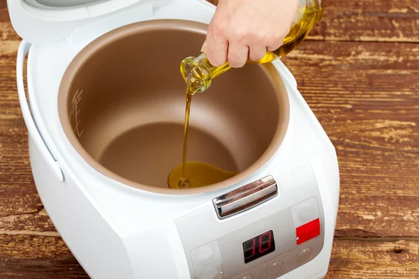 Adăugați ulei de măsline în multicooker — Fotografie, imagine de stoc