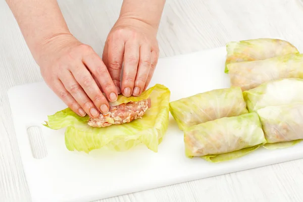 Chef prepares stuffed cabbage rolls — Stock Photo, Image