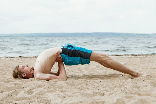 Joven practica yoga en la playa — Foto de Stock