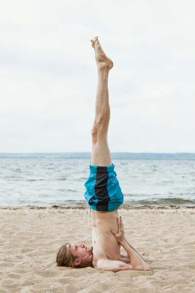 Hombre adulto practica yoga en la playa — Foto de Stock