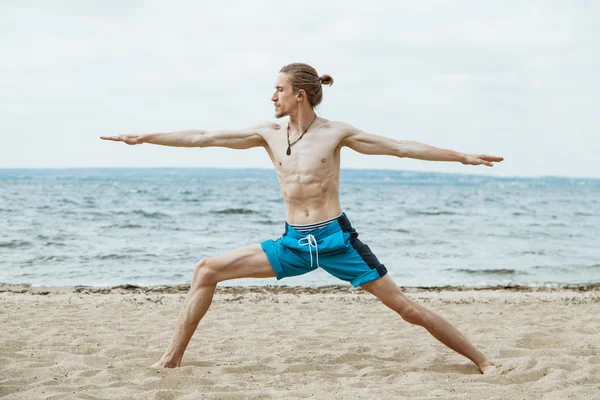 Hombre adulto haciendo yoga en la playa — Foto de Stock