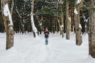 Beautiful girl standing in winter forest