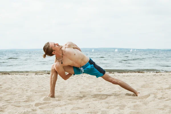 Young man doing yoga on the beach — Stock Photo, Image