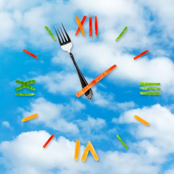Food clock on blue sky background — Stock Photo, Image